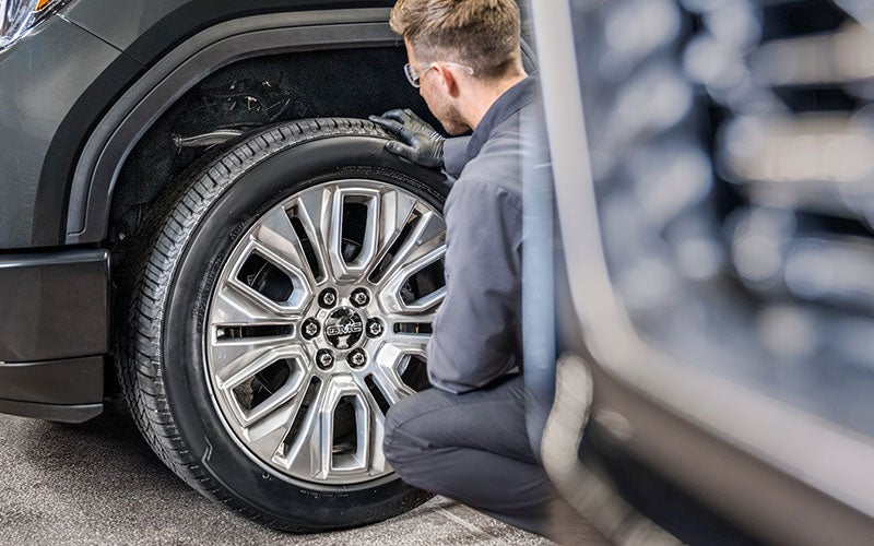 A service expert inspecting tires